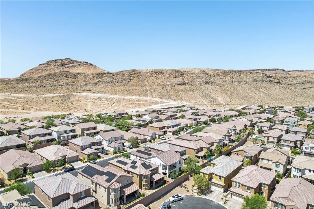 9490 Wild Valley Avenue, Las Vegas, NV 89148 Desert mountains rise behind a quiet neighborhood of contemporary homes.