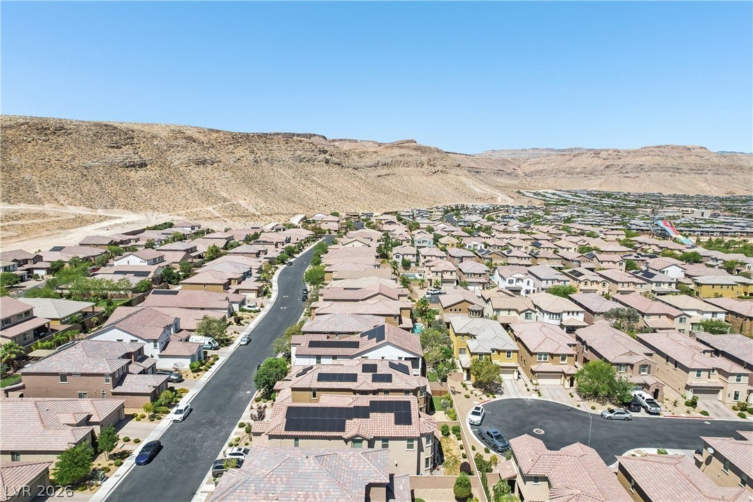 9490 Wild Valley Avenue, Las Vegas, NV 89148 A sprawling neighborhood of tile-roofed homes sits nestled against a dramatic desert hillside.