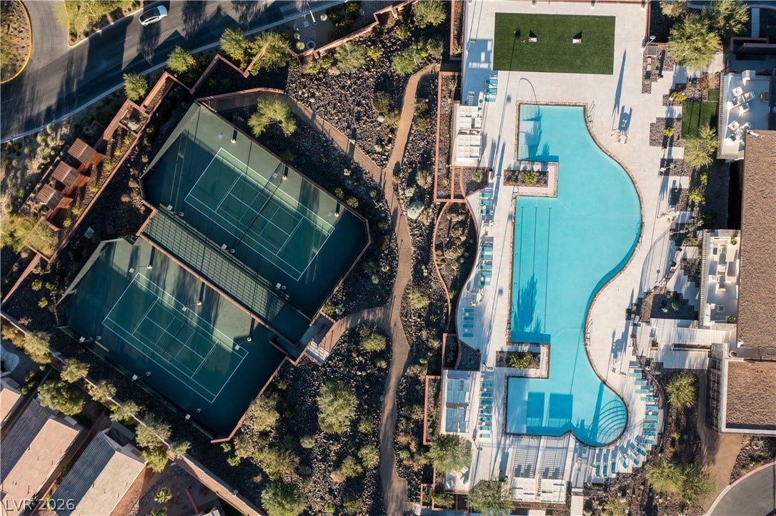 7 Chisel Crest Court, Henderson, NV 89012 A bird's-eye view highlights the community recreation center, featuring tennis courts and a sparkling swimming pool.