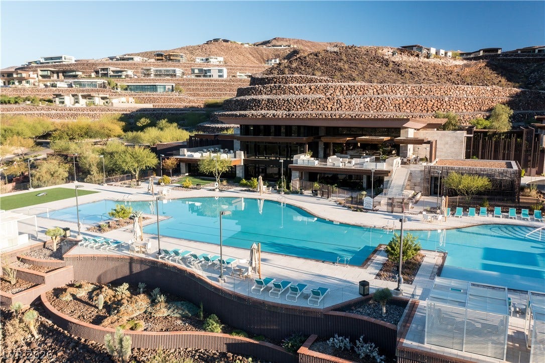 7 Chisel Crest Court, Henderson, NV 89012 Terraced desert hillsides frame a modern resort-style swimming facility with sleek architecture.