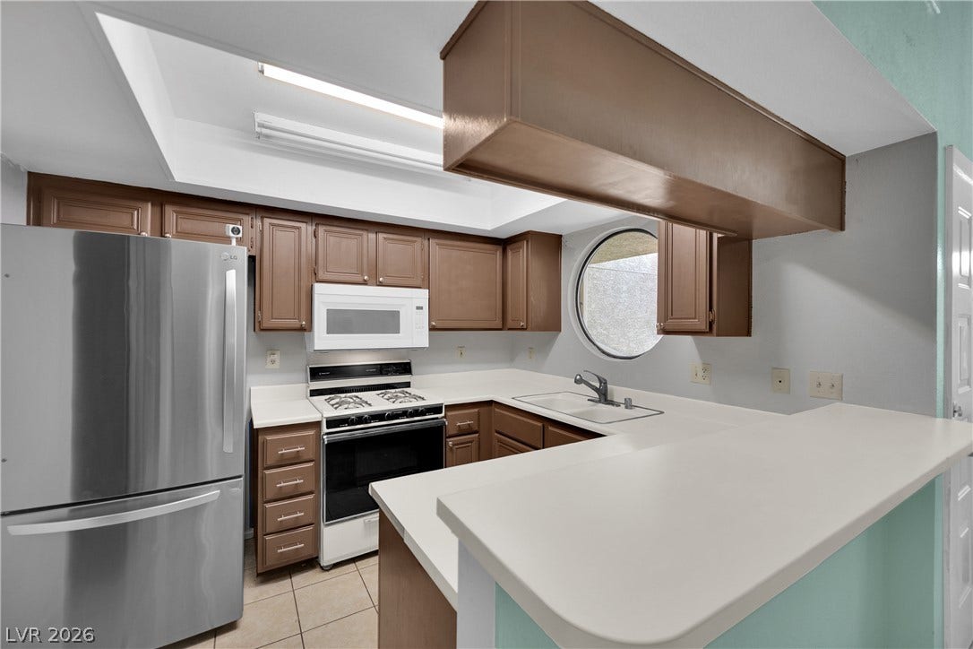 Streamlined cabinetry and classic stone counters define this functional cooking space.