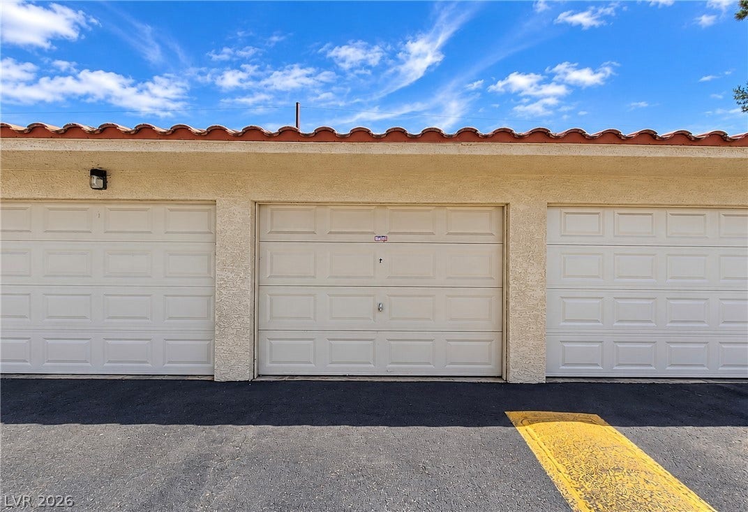 A Spanish tile roof accents this exterior parking structure with multiple garage bays.