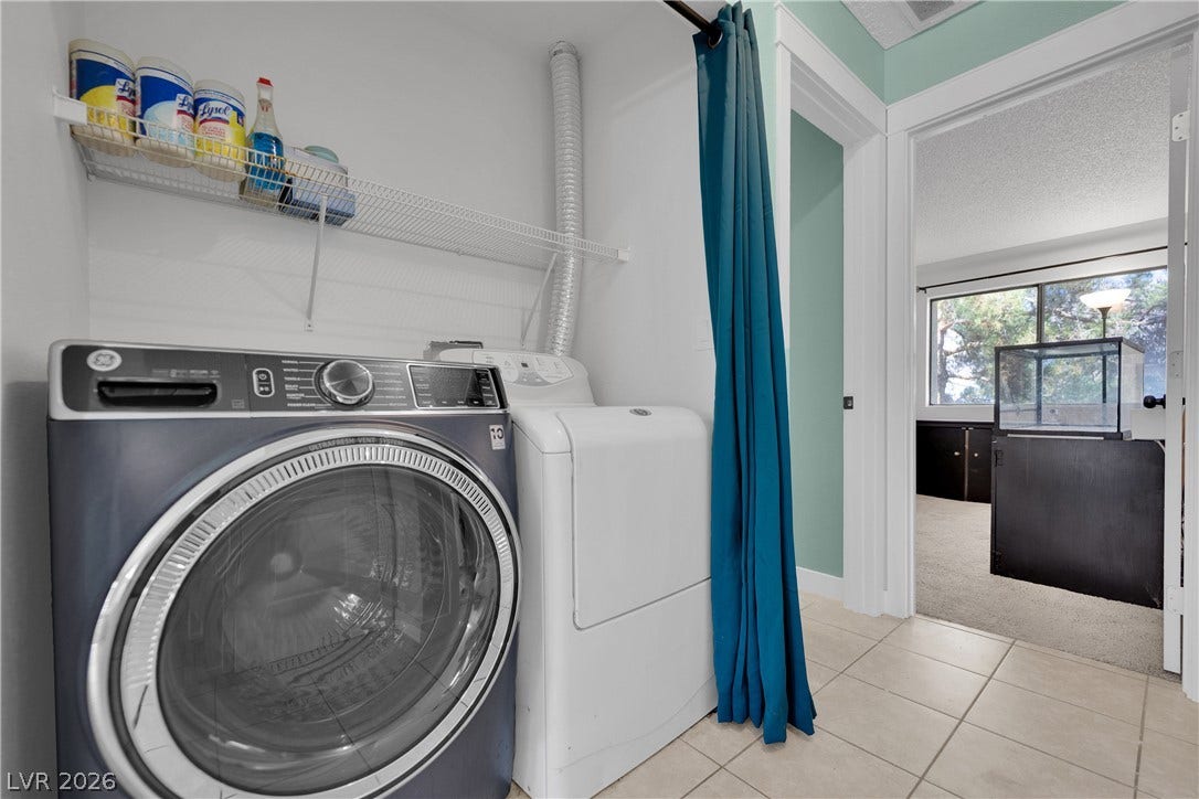 A dedicated laundry space features tile flooring and convenient wire storage shelving.