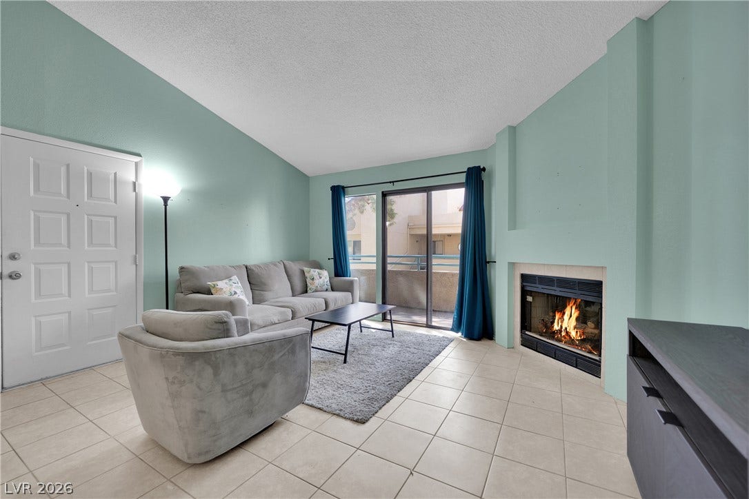 Vaulted ceilings and a wood-burning fireplace create an inviting atmosphere in this main living space.