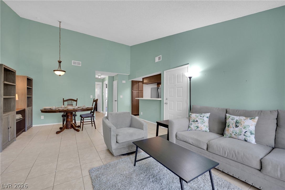 An open layout connects the dining space and living area under soaring vaulted ceilings.