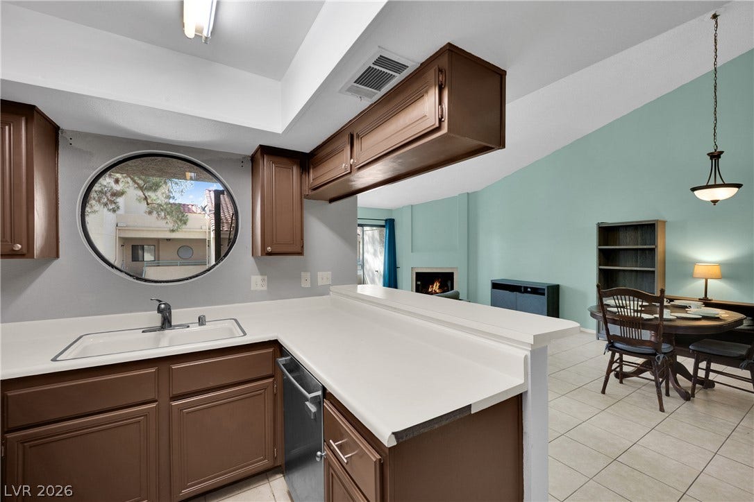 An open layout connects the kitchen work area to the vaulted dining and living spaces.