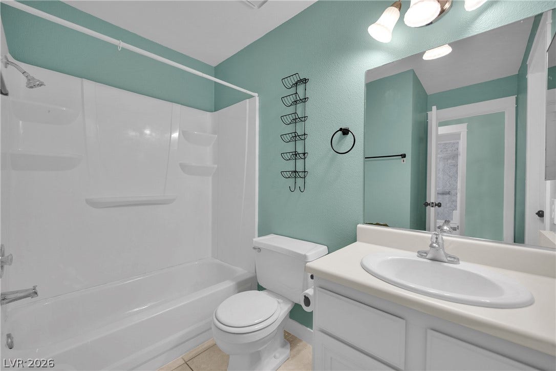 A classic bathtub and shower combination sits adjacent to a white vanity with integrated sink.