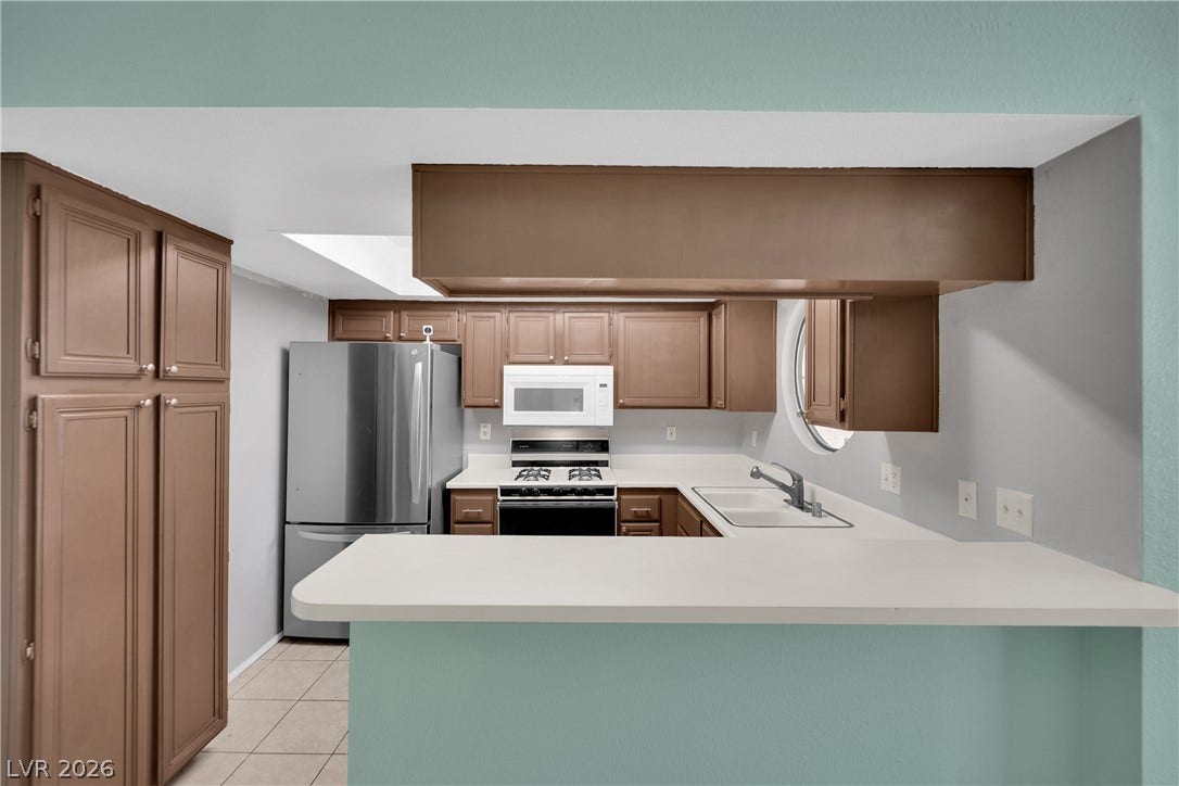 A breakfast bar opens this functional workspace to adjacent living areas.