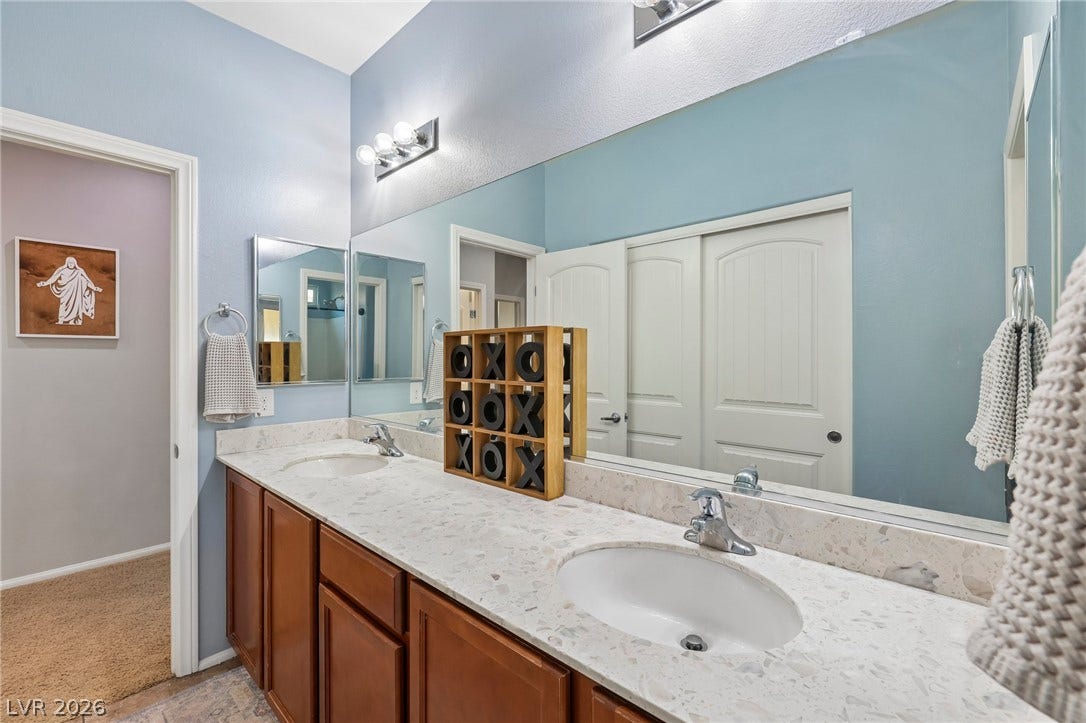Double vanity with stone counters provides ample space and sleek design in this well-appointed bathroom.