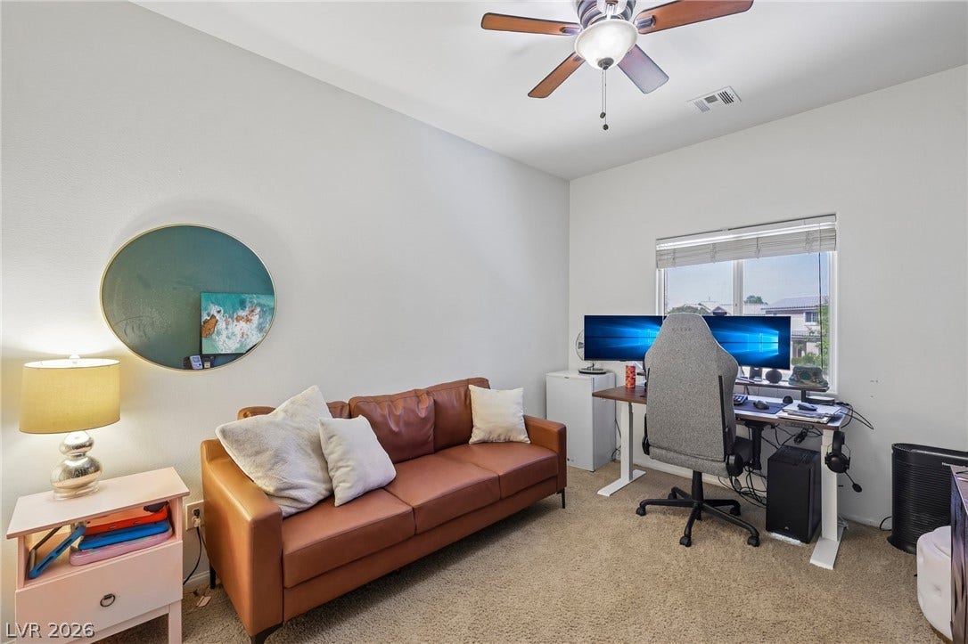 An inviting secondary bedroom offers comfort, featuring carpeted flooring, a ceiling fan, and ample natural illumination.