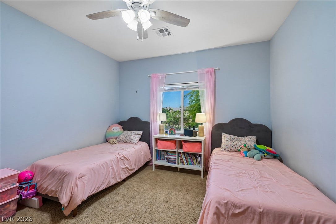 A well-lit bedroom provides comfortable sleeping arrangements and ample natural light through a bright window.