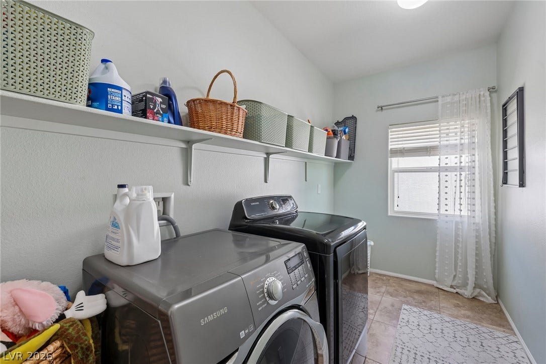 Functional laundry space featuring modern appliances and practical shelving.