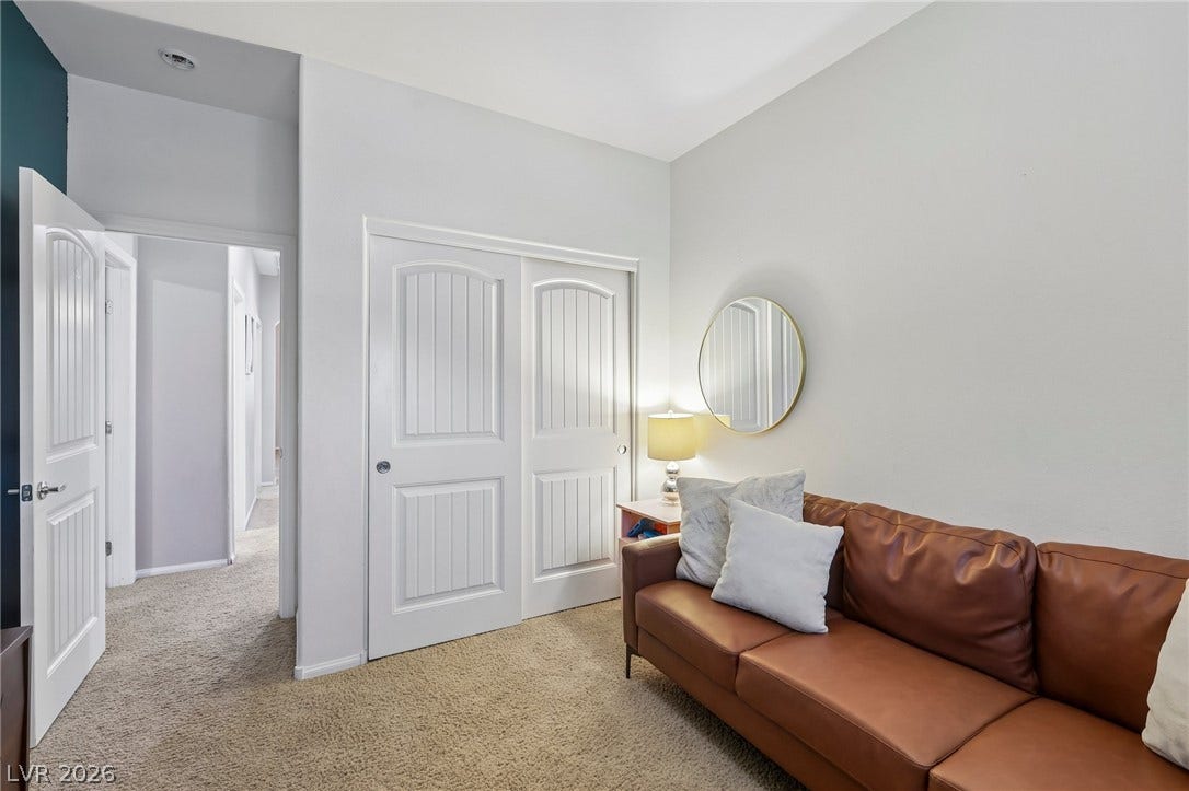 A well-lit bedroom features plush carpeting and two paneled closet doors, providing ample storage.