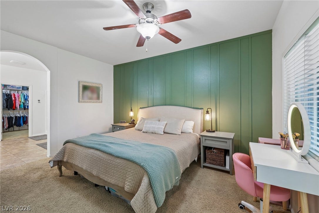 A comforting bedroom with a striking green accent wall and plush carpeting. Located downstairs