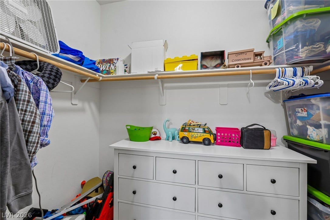 Functional closet featuring ample shelving and a built-in dresser for organized storage.