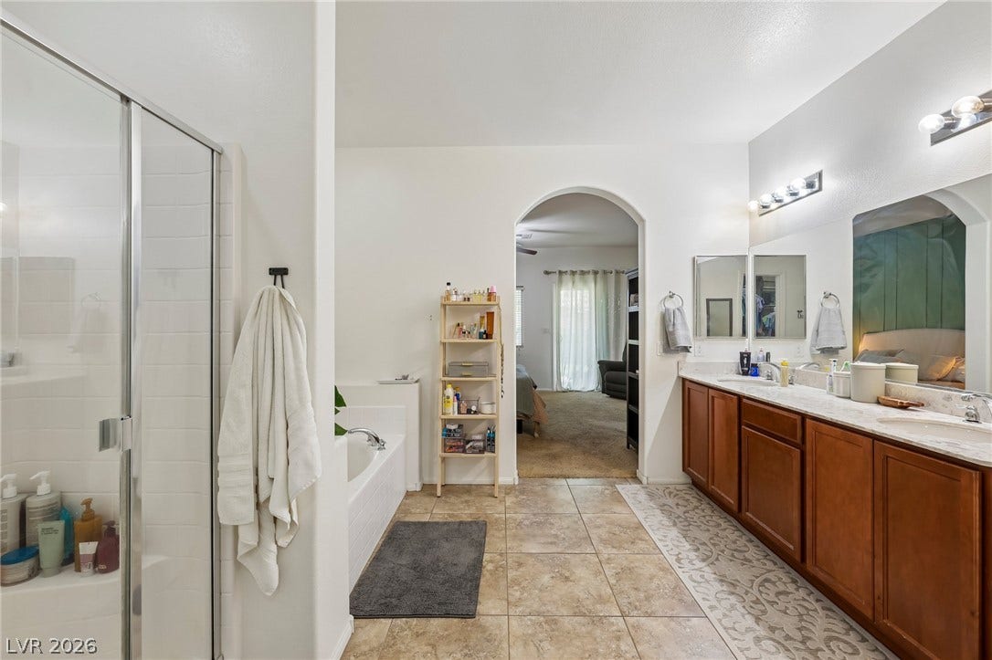 Step into this primary bathroom featuring a spacious dual vanity, separate shower, and soaking tub.