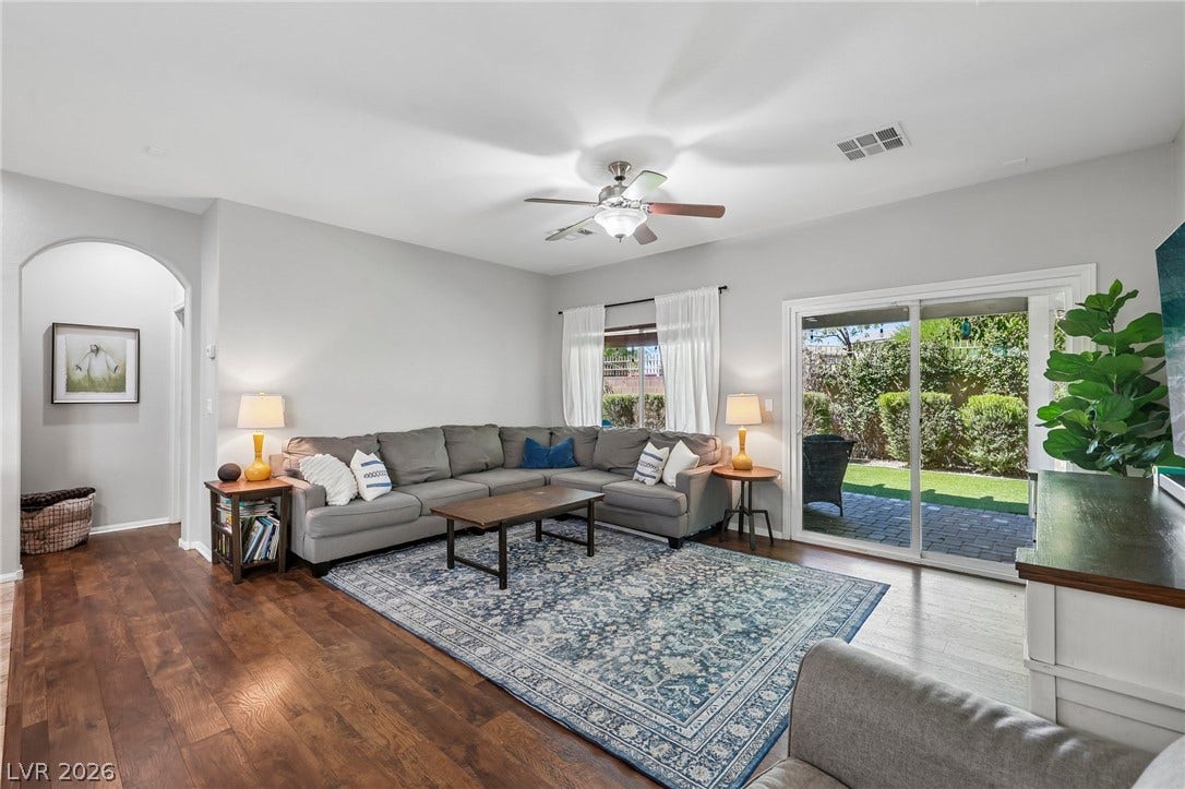 Hardwood flooring and a ceiling fan create a comfortable atmosphere in this inviting living space.