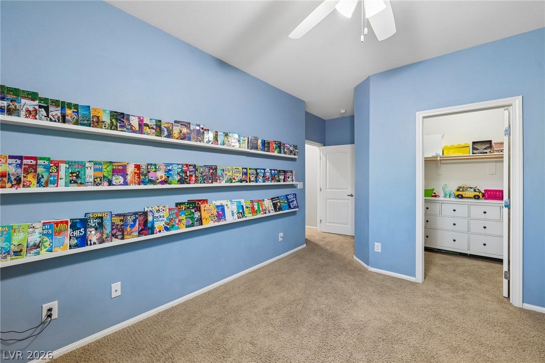 A well-lit bedroom features built-in shelving, carpeted flooring, and a convenient walk-in closet.