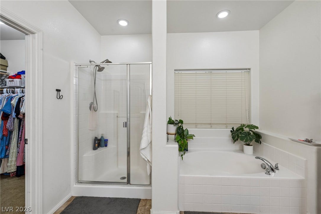 A well-appointed bathroom featuring a glass-enclosed shower and a separate built-in soaking tub, offering a functional retreat.