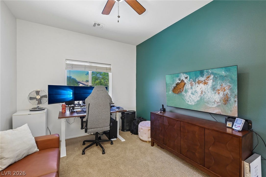 A well-lit interior space with a distinct accent wall and comfortable carpeting offers a functional and appealing environment.