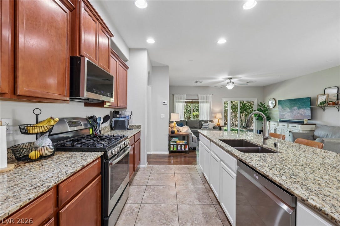 A well-appointed kitchen features rich wood cabinetry, granite countertops, and stainless steel appliances.