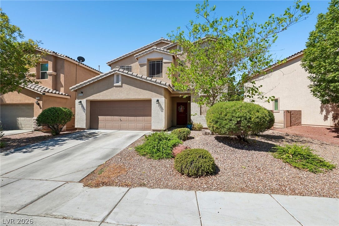 A well-maintained stucco residence offers an inviting curb appeal with its manicured xeriscape landscaping.
