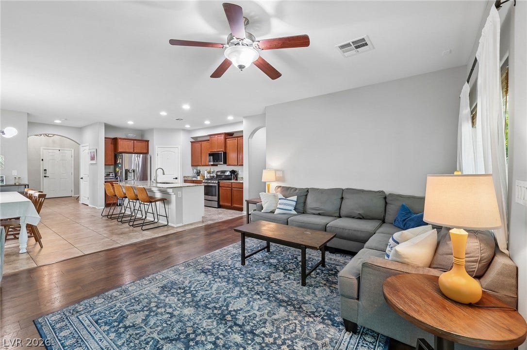 An inviting open-concept living space features warm wood floors and a kitchen with an island perfect for entertaining.