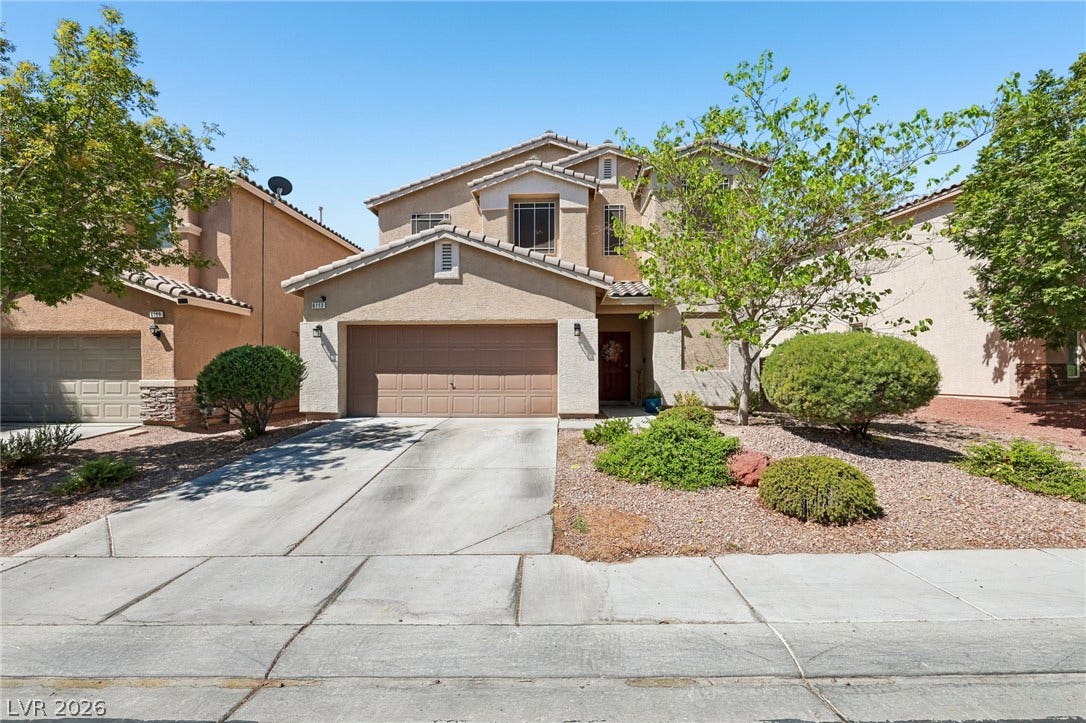 A well-maintained stucco home with an attached garage and desert-friendly landscaping.