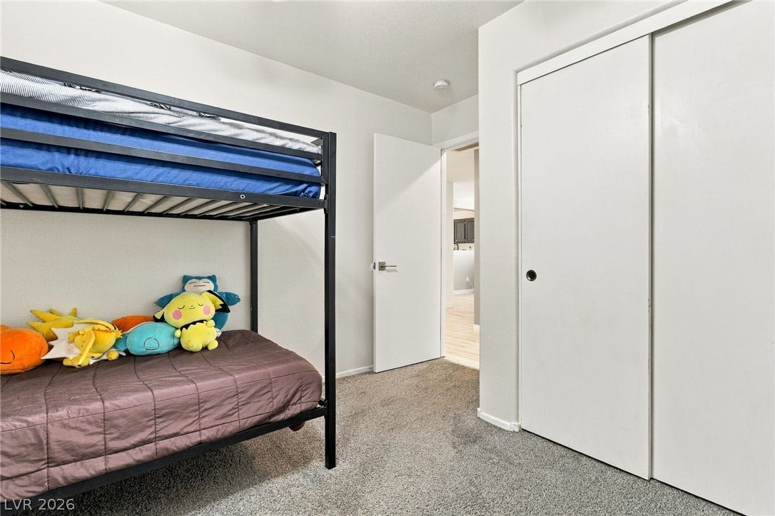 Plush carpeting anchors this comfortable bedroom complete with a sliding closet door.