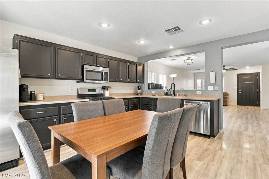Dark cabinetry and wood-look flooring establish a modern aesthetic in this open kitchen space.