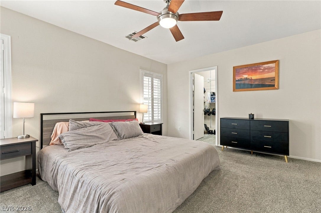 Plush carpeting and plantation shutters define this comfortable, airy bedroom retreat.