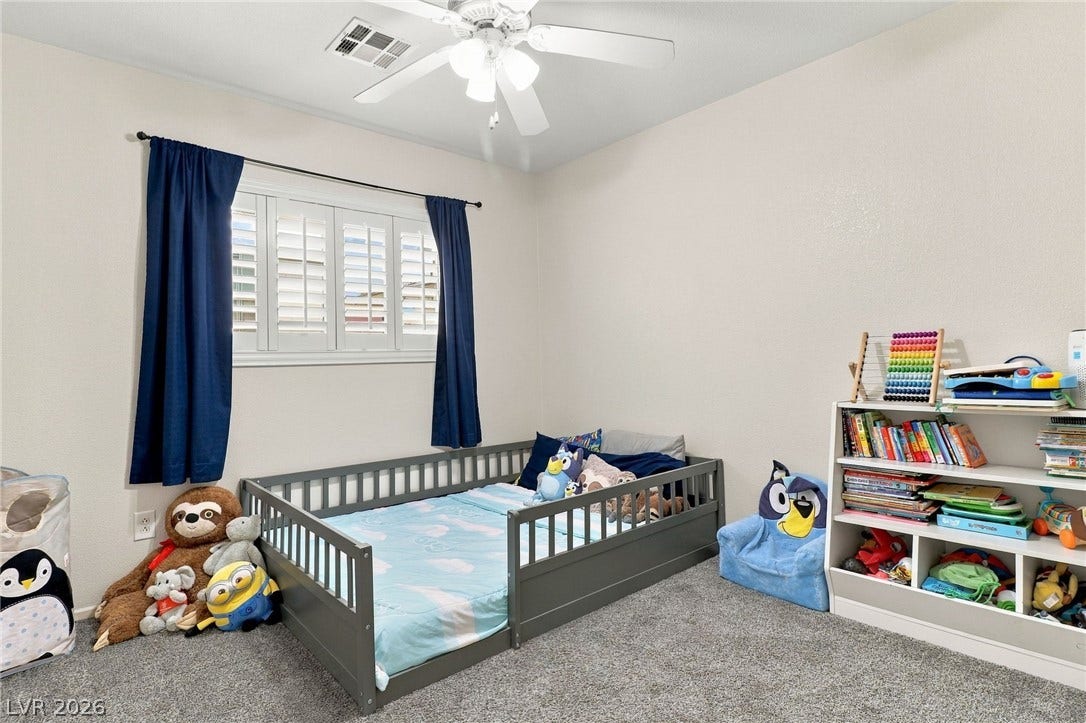 Soft carpeting underfoot and plantation shutters create a cozy, inviting atmosphere in this bedroom.