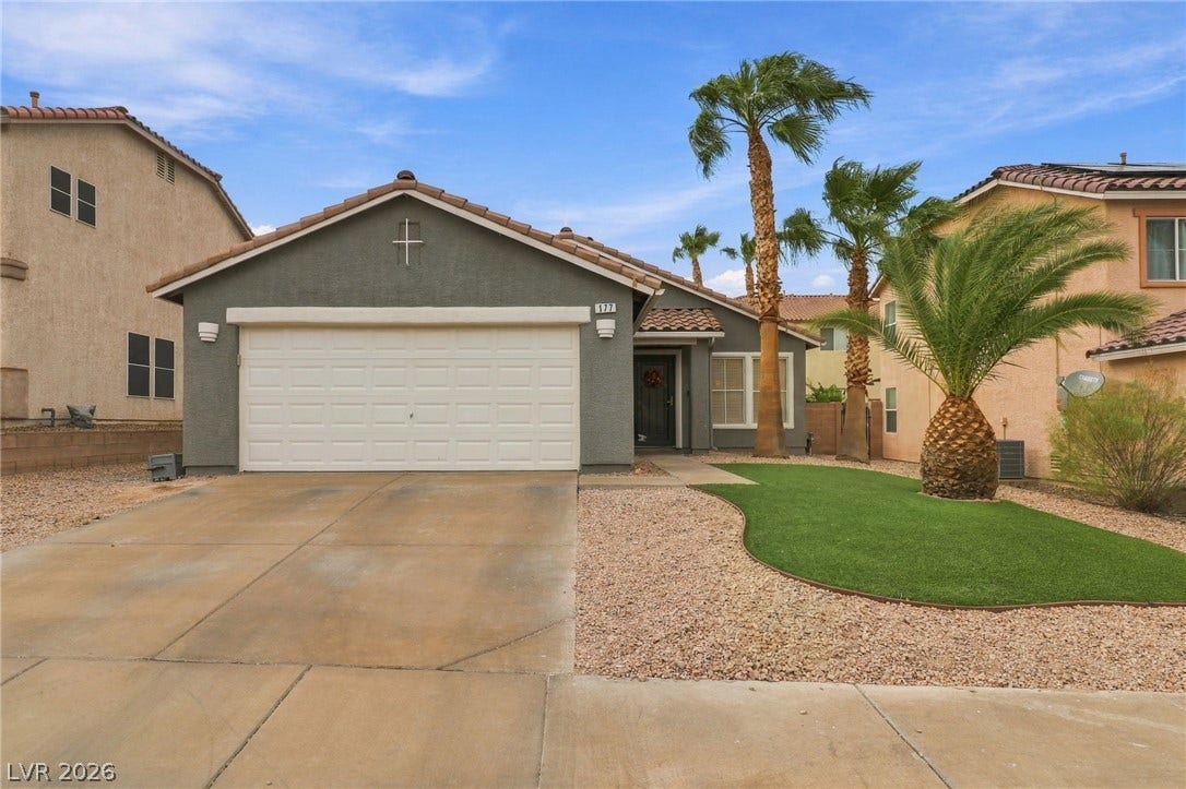 Palm trees frame the front yard of this modern single-story residence with attached garage.