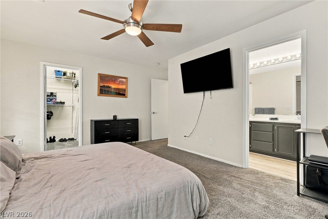 A spacious bedroom features comfortable plush carpeting and direct access to an en-suite bathroom.
