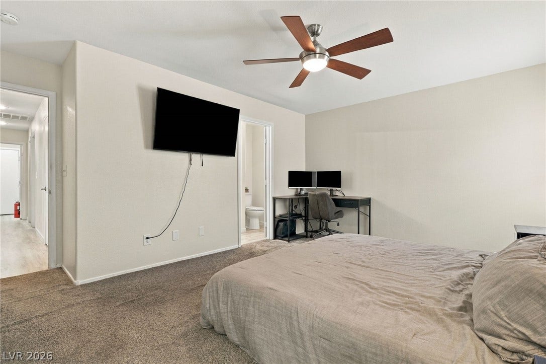An inviting bedroom features comfortable carpeting and direct access to an en suite bathroom.
