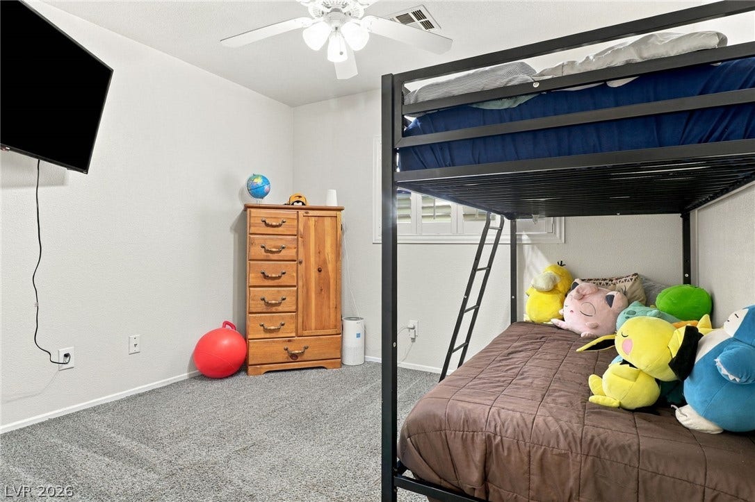 Smooth plaster walls and neutral carpeting anchor this comfortable secondary bedroom space.