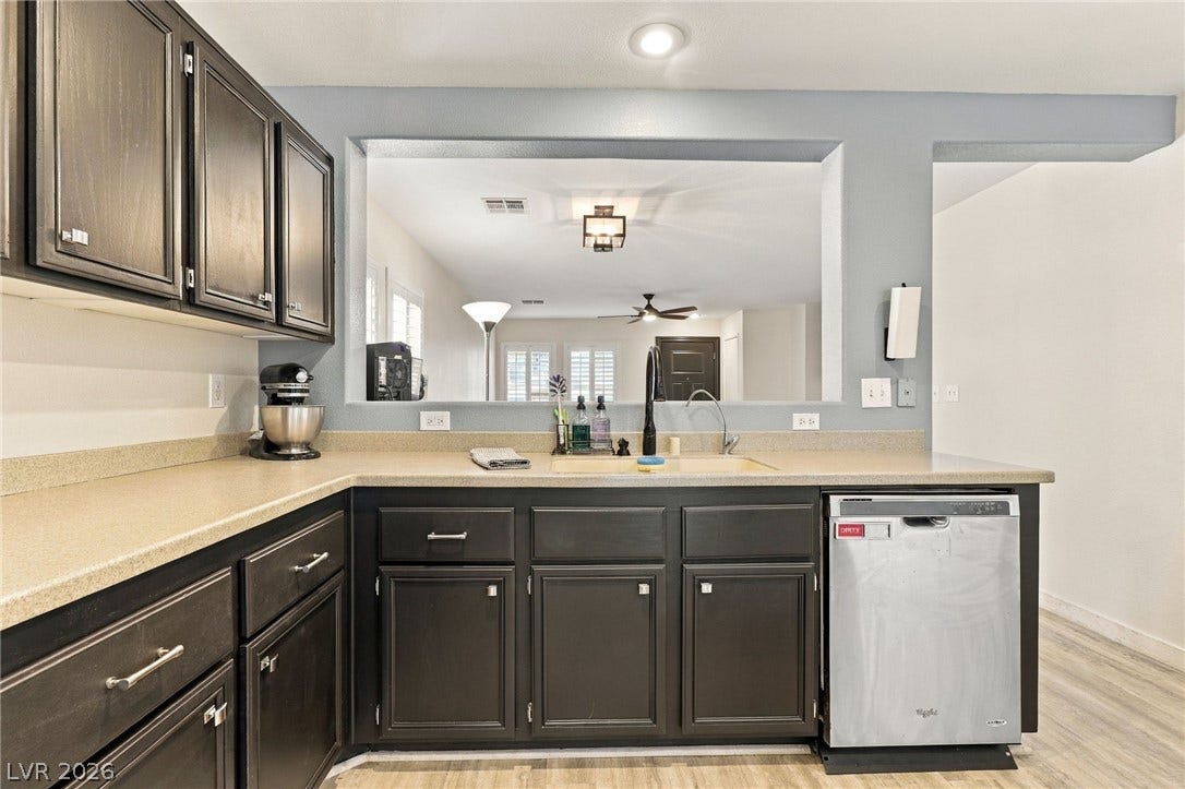 A spacious pass-through window connects this functional kitchen to the adjoining living space.