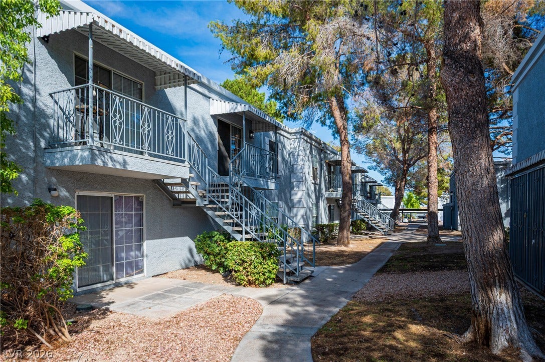 3823 S Maryland Parkway, #B11, Las Vegas, NV 89119 Mature trees shade the pathways and private balconies of this multi-level residential exterior.