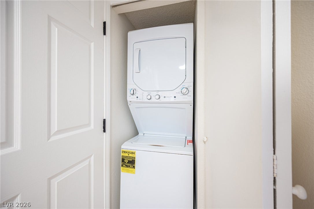 3823 S Maryland Parkway, #B11, Las Vegas, NV 89119 A compact laundry alcove features a stacked washer and dryer set behind a white door.