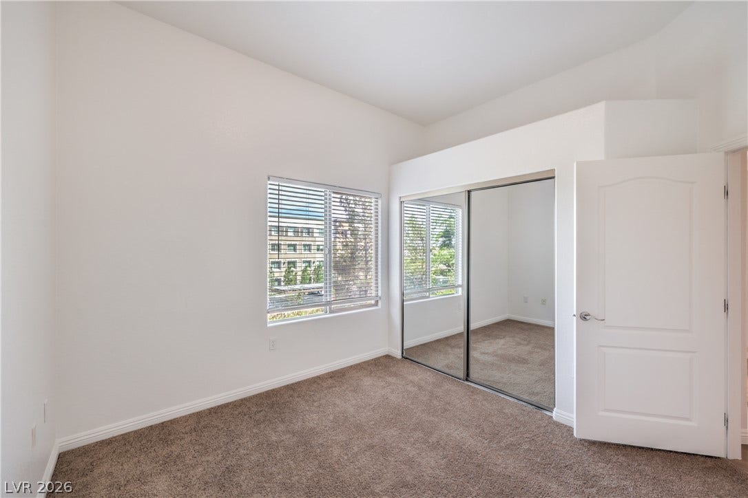 High ceilings and mirrored closet doors enhance the sense of space in this bedroom.