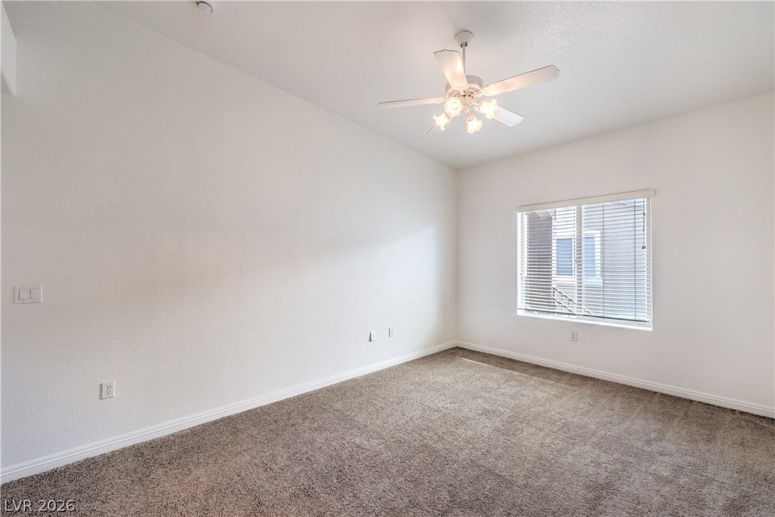 Plush carpeting and high ceilings define this versatile, window-lit secondary space.
