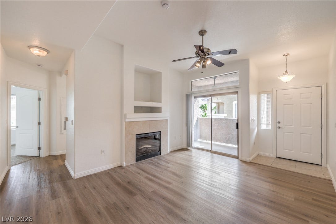 An inviting fireplace serves as the centerpiece of this open living space with wood-style flooring.