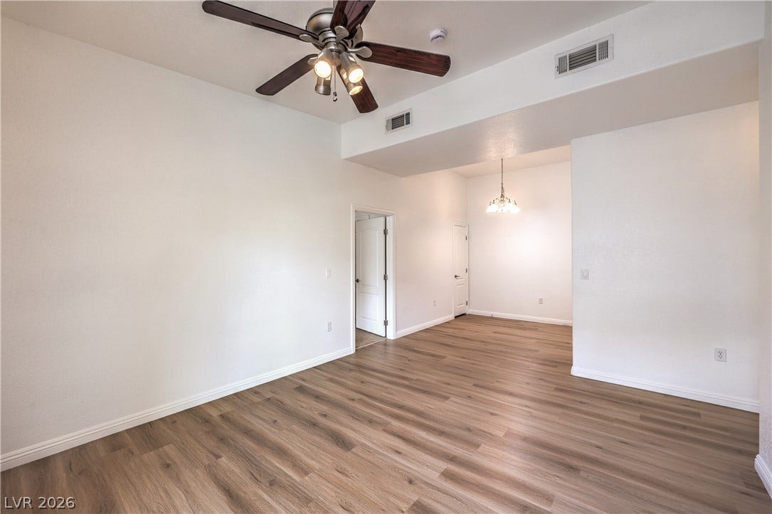 Smooth wood-look flooring and tall ceilings enhance this open, versatile living space.
