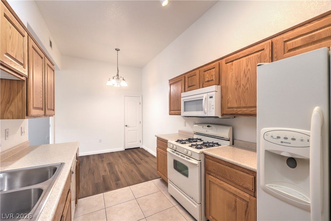 Oak cabinetry paired with neutral countertops anchors this functional kitchen space.