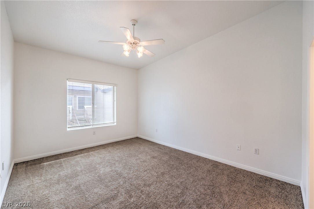A windowed secondary bedroom features wall-to-wall carpeting and clean baseboard molding details.