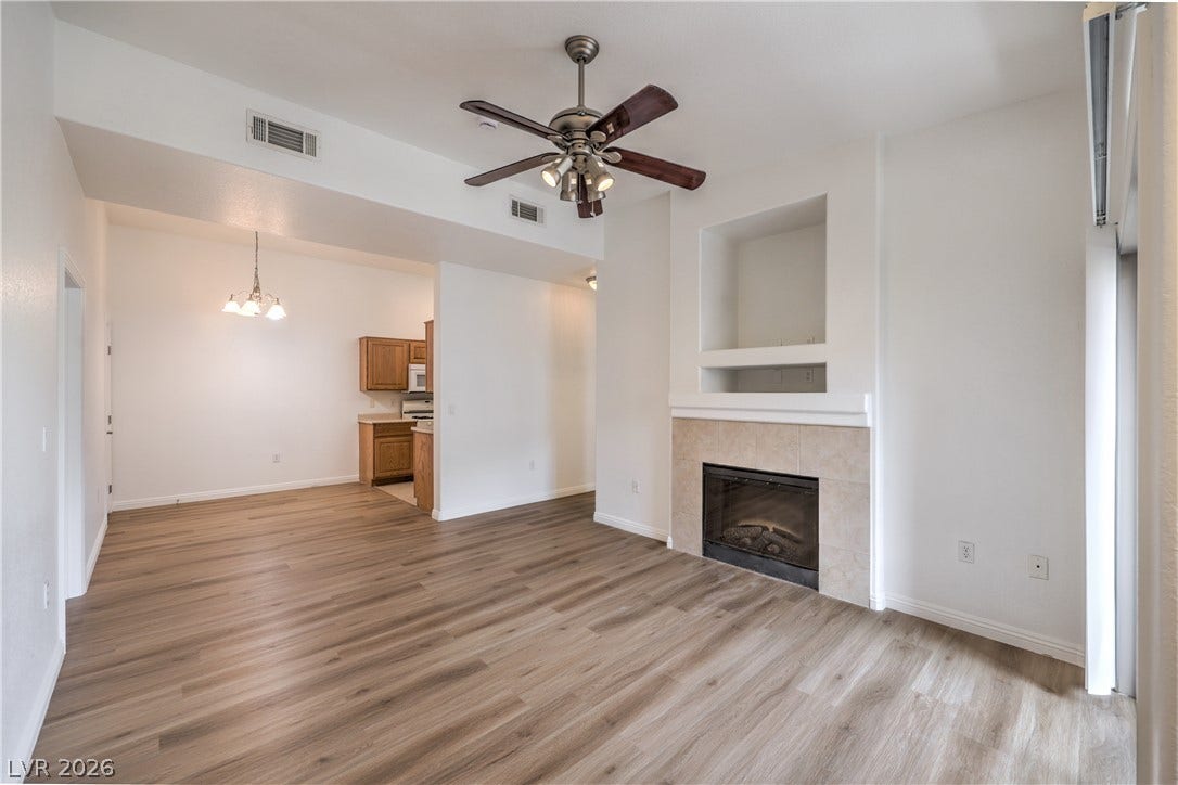 A tiled fireplace acts as a focal point in this open living area with wood flooring.