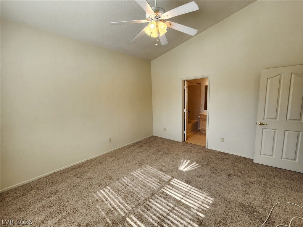 8301 Boseck Drive, #237, Las Vegas, NV 89145 Vaulted ceilings soar over plush carpeting in this private bedroom featuring an attached bath.