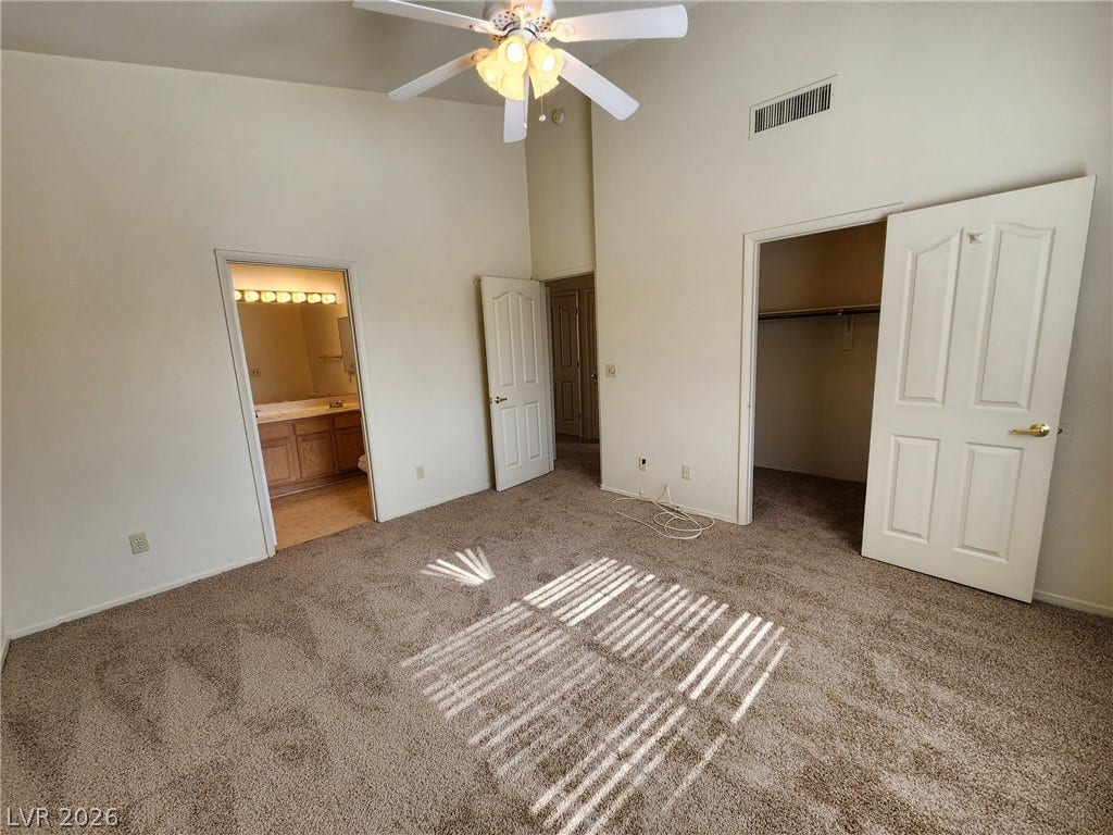 8301 Boseck Drive, #237, Las Vegas, NV 89145 A spacious bedroom features soft carpeting, high vaulted ceilings, and direct access to an en-suite bath.
