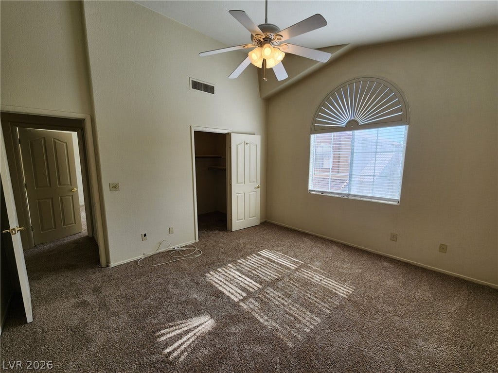 8301 Boseck Drive, #237, Las Vegas, NV 89145 High vaulted ceilings and arched windows elevate this carpeted bedroom.