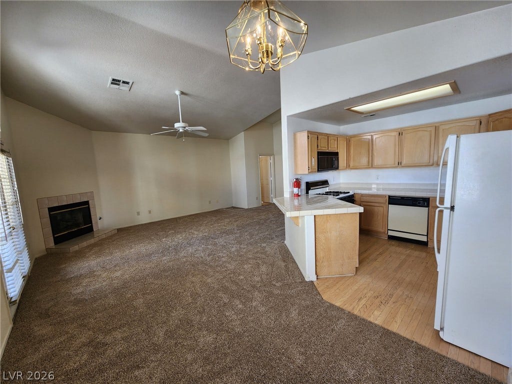 8301 Boseck Drive, #237, Las Vegas, NV 89145 An open layout connects the tiled-counter kitchen to a fireplace-warmed living space.